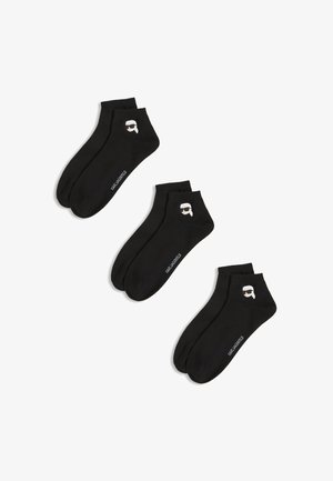 Chaussettes noires en coton arrivant aux chevilles, ornées d'un design graphique d'une tête avec des lunettes de soleil et du texte "KARL LAGERFELD" sur le côté.