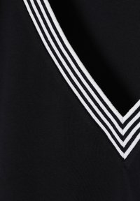 Laine navy dengan desain leher V yang menampilkan kerah ribbed bergaris putih. Tekstur halus dengan ribbing vertikal pada kain.