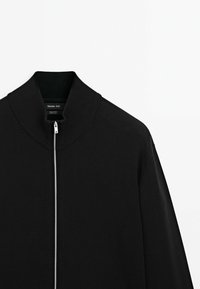 Giacca nera con zip realizzata in cotone, con colletto e polsini a coste, dal design minimalista e senza motivi visibili.