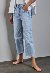 Jasnoniebieskie, krótkie dżinsy z wysokim stanem, dwoma przednimi kieszeniami oraz wyblakłą fakturą denimu. Zaprojektowane z szeroką nogawką i dołem.