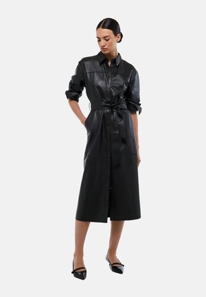 Robe chemise en simili cuir noir avec des manches longues, une taille ceinturée, une fermeture à boutons sur le devant et une longueur au genou. Texture lisse avec une finition brillante.