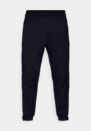 Mustad mustad pükse pehmest kangast, millel on külje tõmblukud, elastne vöökoht ja tihedad mansetid pahkluude juures.