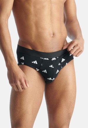 Caleçons noirs avec un motif triangulaire blanc répété. Tissu doux avec une ceinture élastique noire, design ajusté qui épouse le corps.