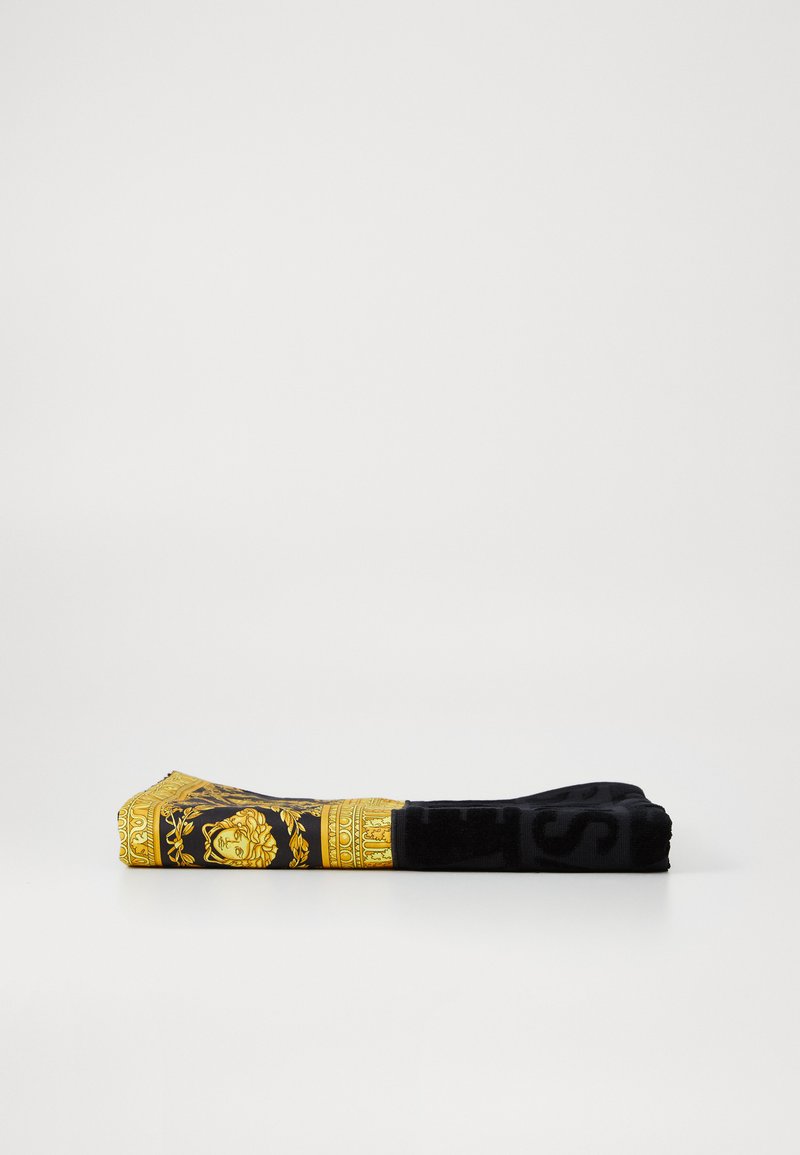 Schwarzes Tuch mit einem gelben barocken Muster mit Löwenmotiven und goldenen Akzenten; glatte Textur und rechteckige Form.