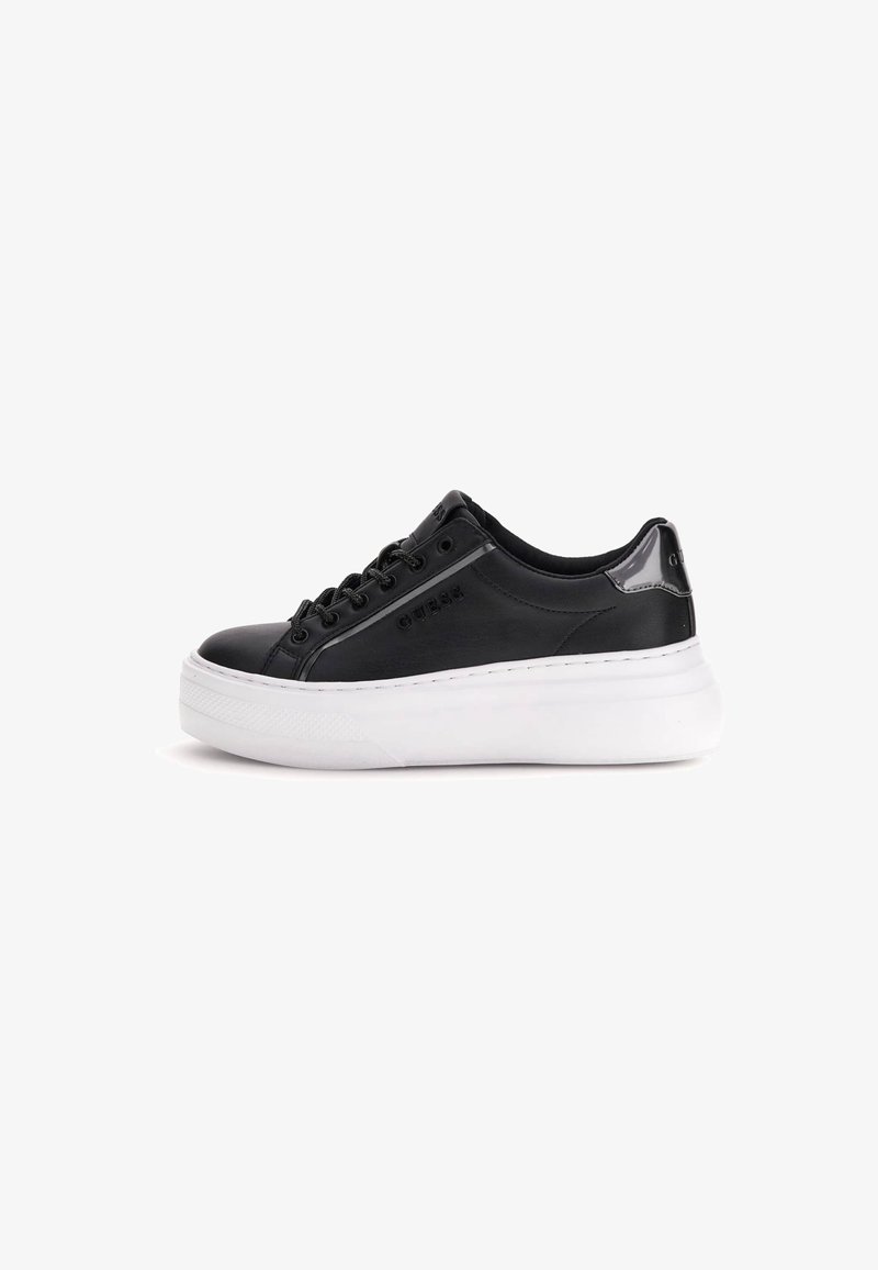 Baskets basses en cuir noir avec semelle plateforme blanche, lacets noirs et logo de la marque sur le côté et le talon.