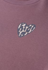 Tissu violet avec un col côtelé comportant un petit patch en forme de cœur avec un motif animalier bleu et blanc.