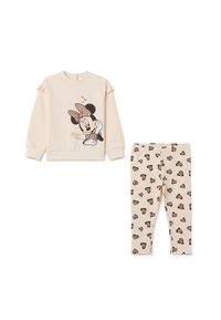 Sweatshirt beige clair avec des manches volants mettant en avant un motif de Minnie Mouse; leggings beige assortis avec des motifs de cœurs marron.