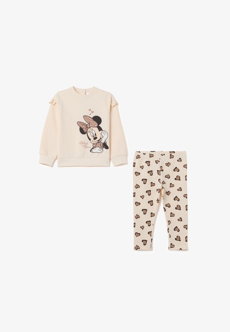 Sweatshirt beige clair avec des manches volants mettant en avant un motif de Minnie Mouse; leggings beige assortis avec des motifs de cœurs marron.