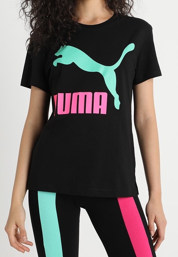 Camiseta negra con logo de Puma en turquesa y letras en rosa. Combinada con mallas negras que tienen franjas turquesa y rosa a lo largo de los lados.