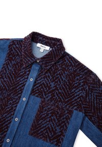 Overhemd met knopen in een gemengd ontwerp in donker bordeauxrood en blauw, met een gestructureerd patroon op het bovenste gedeelte en denimstof eronder.