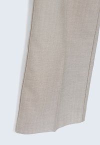 Tissu beige avec un motif chevrons subtil et une couture verticale cousue le long du bord latéral.