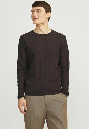 Pulover lung cu maneci lungi, de culoare maro închis, cu un guler rotund, asociat cu pantaloni de culoare maro deschis. Textură netedă, design ajustat.