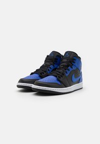 Un par de zapatillas altas negras y azules con cordones negros y suelas blancas, posicionadas una al lado de la otra sobre un fondo blanco.