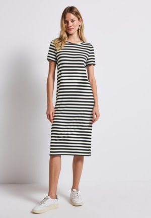 Gestreiftes T-Shirt-Kleid in Creme und Schwarz, mit kurzen Ärmeln, Rundhalsausschnitt und einem seitlichen Schlitz für optimale Bewegungsfreiheit.