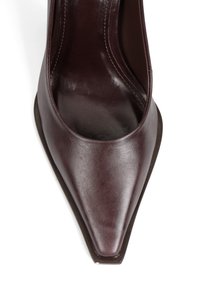 Burgundowe skórzane czółenka z szpiczastym noskiem i eleganckim, gładkim wykończeniem. Projekt charakteryzuje się niskim cięciem oraz subtelną, kontrastującą brązową podeszwą.