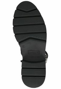 Suela de zapato de goma negra con patrones de surcos profundos, con una puntera redondeada y secciones elevadas para facilitar la tracción. Marcada con la talla 37 y el logo de la marca.