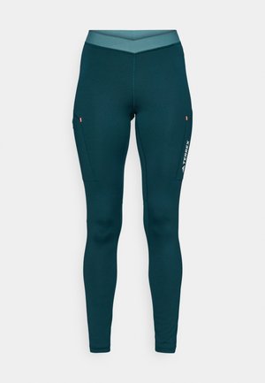 Tamsiai mėlynos sportinės legginsai su aukštu juosmeniu, su šoninėmis kišenėmis ir baltu logotipu apatinėje kojoje. Lygus, tamprus audinys.