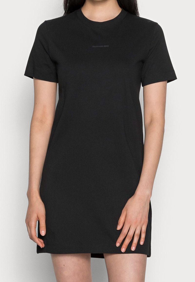 Svart bomulls t-shirtklänning med korta ärmar, rundad halsringning och rak skärning. Har en subtil Calvin Klein jeans-logotyp på bröstet.