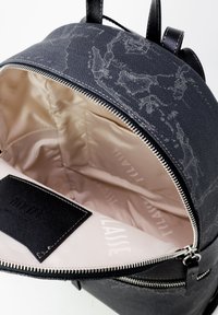 Zaino nero con una texture e un motivo marmorizzato grigio; presenta un'apertura con zip, foderatura interna beige e un'etichetta nera all'interno.