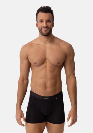 Schwarze Boxer Shorts mit glatter Textur, die ein enganliegendes Design und einen elastischen Bund aufweisen. Der Stoff wirkt atmungsaktiv und bequem.