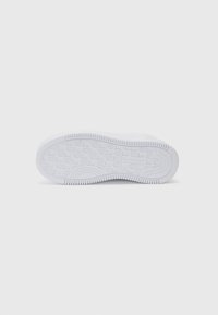 Biała gumowa podeszwa sneakersów z okrągłym wzorem bieżnika i poziomymi rowkami. Wytłoczone logo marki w pobliżu części pięty.