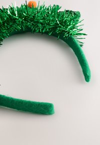 Green headband adorned with shiny green tinsel and a small orange pom-pom on top, featuring soft felt-covered sides.