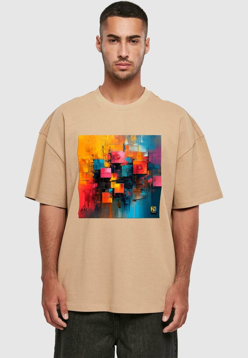 Tricou oversized bej, cu un imprimeu abstract colorat în nuanțe de albastru, portocaliu, roz și negru. Mâneci scurte și croială lejeră.