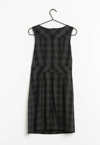 Svart och grå rutmönstrad klänning med figursydd överdel, breda axelband och plisserad kjol. Slät textur och dragkedjestängning bak.