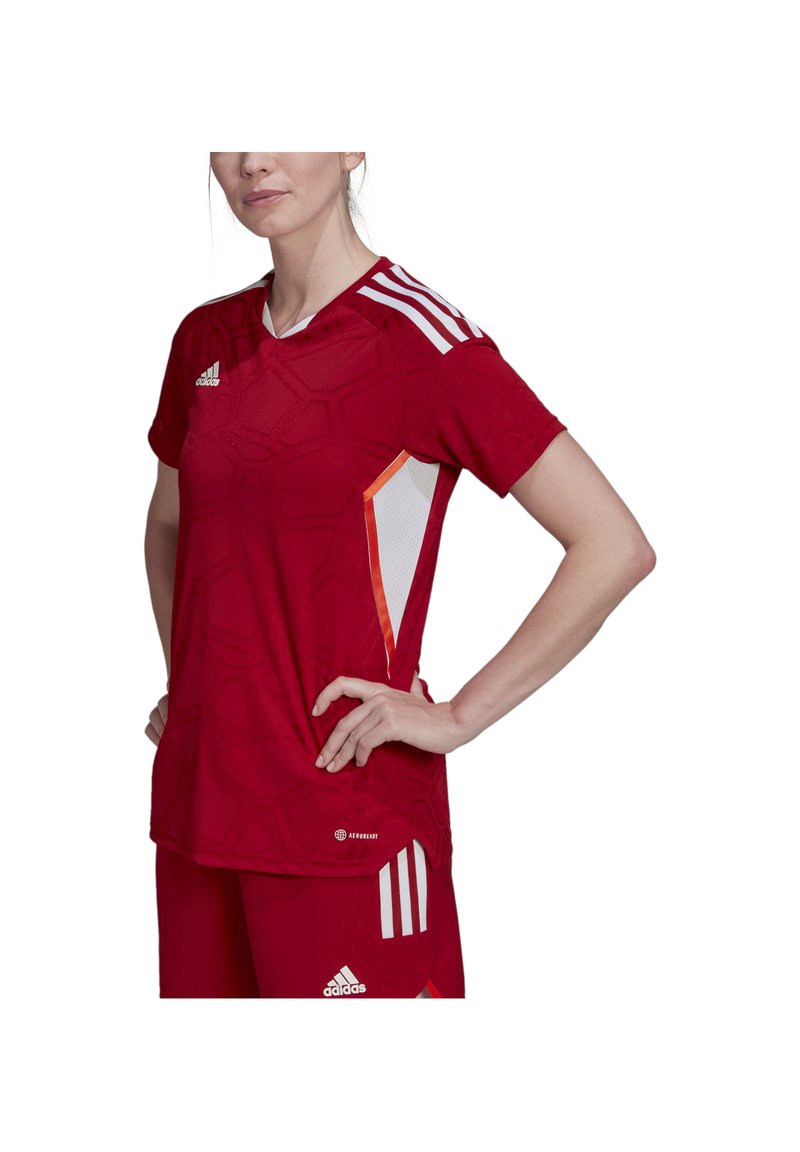 Rote Sportjersey mit strukturiertem Muster, weißen Mesh-Details und drei weißen Streifen auf den Schultern. Enthält Logodetails.