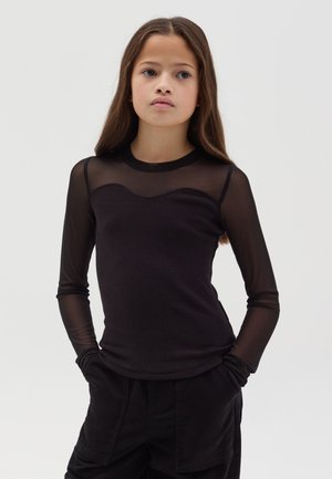 Black long-sleeve top with a sheer mesh overlay and ribbed body. Features a round neckline and fitted design, paired with dark pants.