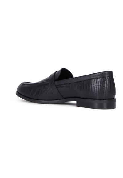 Sorte læder loafers med en struktureret overflade, der har en glat rem over på toppen og en lav, flad gummisål.