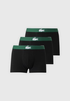 Tre sorte boxershorts med grønne taljebånd, der har en hvid krokodille-logo centralt på hvert taljebånd.