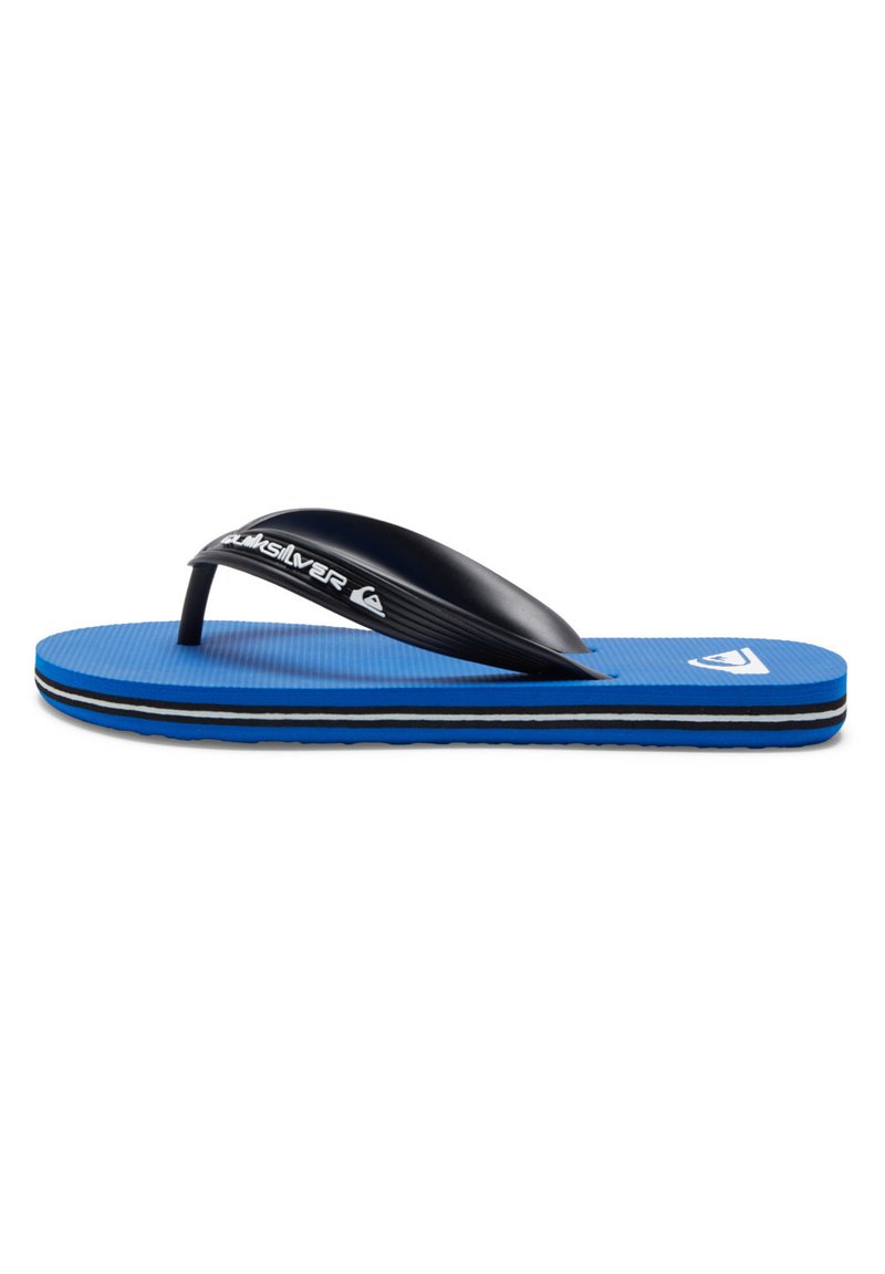 Sininen flip-flop, jossa on teksturoitu kumi-pohja, musta thong-hihna ja kontrastivalkoinen logo. Ominaisuuksiin kuuluu kerrosrakenteinen pohja, jossa on mustia ja valkoisia raitoja.