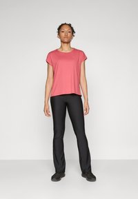 Red T-shirt with cap sleeves, paired with black fitted pants and black shoes. The outfit features a simple, smooth texture with no patterns.