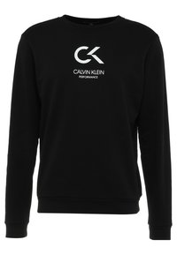 Sweatshirt noir en mélange de coton, avec des manches longues et un col rond. Un logo blanc avec le texte "CALVIN KLEIN PERFORMANCE" est affiché.