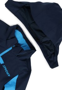 Marineblau wasserdichte Jacke mit einem hellblauen Innenfutter, einem Reißverschluss vorne und einer abnehmbaren Kapuze. Enthält Akzente und ein Logo.