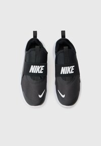 Bottes noires Nike à enfiler avec une tige en maille texturée, une sangle élastique et des accents de logo blancs. Semelle légère avec une finition lisse.