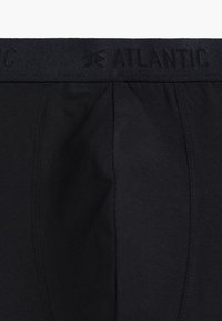 Czarne bokserki z teksturowanym paskiem w talii, zdobionym wytłoczonym napisem marki. Gładka bawełniana tkanina o dopasowanym kroju, bez dodatkowych wzorów.