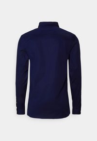 Tumedat sinine pika varrukaga särk struktureeritud kraega. Sile tekstuur, nööpidega mansetid ja kergelt kõver hem. Pole nähtavaid mustreid ega aksessuaare.