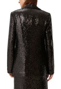 Czarny żakiet z cekinami o eleganckim kroju, z dopasowanym kołnierzem i długimi rękawami, prezentujący błyszcząca, teksturowana powierzchnię.