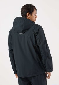 Black waterproof jacket with a hood, elastic cuffs, and adjustable hem. Features a logo on the upper back and smooth, lightweight fabric.
