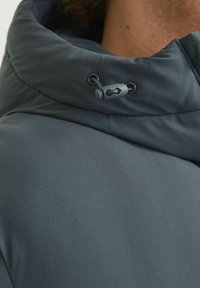 Gray hooded jacket featuring a smooth, matte texture, adjustable drawstring hardware, and a structured collar.