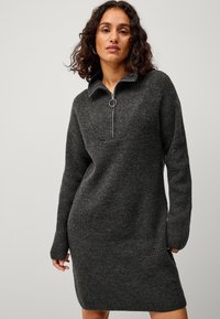 Donkere grijze gebreide sweaterjurk met een ritskraag, lange mouwen en een relaxte pasvorm met geribbelde textuur en details.