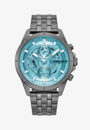 Hõbedane metallkell ümmarguse türkiissinise kellapaneeli, kolme alampaneeli, valgete tunni markerite ja roostevabast terasest rihmaga. Brändi nimi "POLICE" on nähtavalt väljendatud.