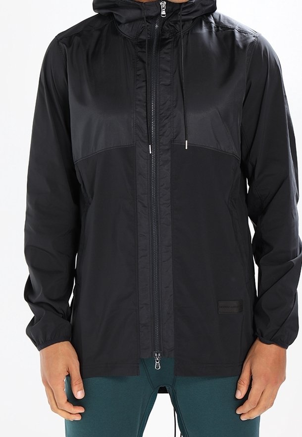 Black, lightweight jacket with a zip front, hood, and elastic cuffs. Features a smooth texture and contrasting upper section design.