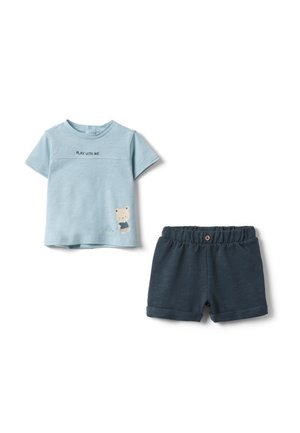 Hellblaues Kleinkind-T-Shirt mit der Aufschrift "SPIEL MIT MIR" und Teddybär-Grafik, kombiniert mit marineblauen Shorts mit elastischem Bund.