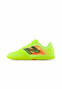 Baskets de sport jaune fluo avec des accents noirs, une semelle texturée et un motif de flammes asymétrique. Comprend des lacets et un col rembourré.