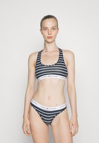 Ensemble de bikini rayé bleu marine comprenant un soutien-gorge de sport à larges bretelles et un bas taille basse assorti, tous deux ornés de bandes élastiques de marque contrastantes.