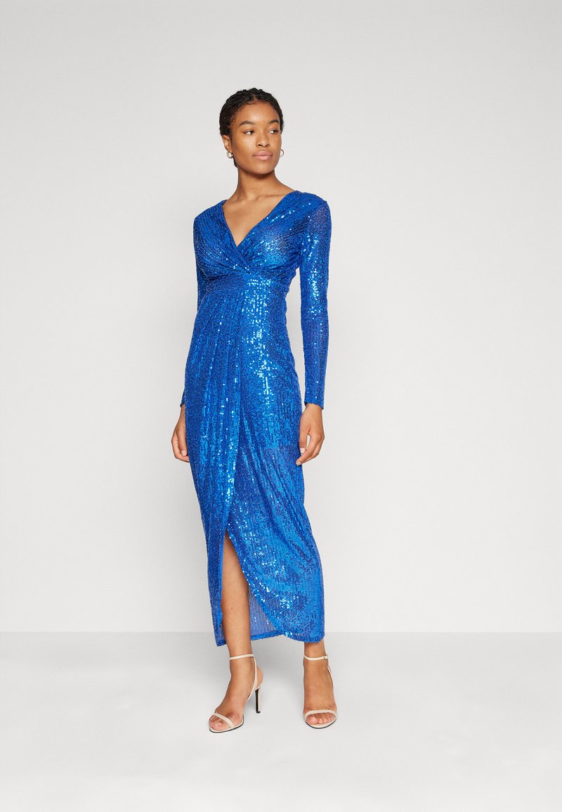 Μπλε φορεμα με παγιέτες, με βαθύ V-ντεκολτέ και μακριά μανίκια; διαθέτει σχισμή στο πλάι και εφαρμοστή κορσέ που καταλήγει σε μήκος κάτω από το γόνατο.