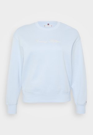 Light blue crewneck sweatshirt made of soft fabric. Features embroidered "Tommy Hilfiger" logo in white, ribbed cuffs, and hem.